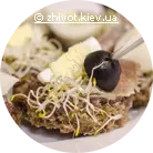 Оселедець на подушці з оливкової сальси на тості